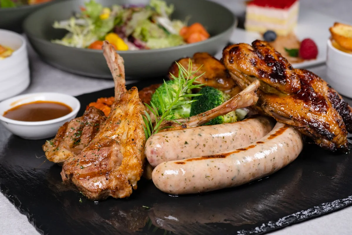 A buffet spread of roasted meats, vegetables and salad set out for a shared evening meal
